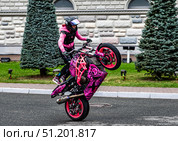 Девушка (Stunt Champ Дарья Харченко) на спортивном розовом мотоцикле, акробатические трюки. Редакционное фото, фотограф Илья Лернер / Фотобанк Лори