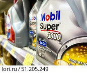 A row of Mobil Super 3,000 oil bottles are on a shelf. Russia. Moscow. 24.08.25. Редакционное фото, фотограф Ярославский Максим / Фотобанк Лори