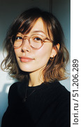 Young Woman With Glasses Poses Confidently Against a Plain Background Indoors. Стоковое AI-изображение, AI-художник Юлия Гапеенко / Фотобанк Лори