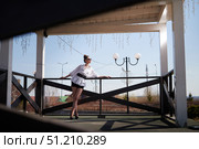 Woman posing confidently on a balcony under a clear blue sky during daylight in an outdoor setting. Стоковое фото, фотограф Кривошеина Елена Леонидовна / Фотобанк Лори