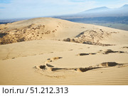 Sarykum dune, the largest sand dune in Europe.. A desert scene with a large mound of sand. The sand is dry and the sun is shining brightly. Стоковое фото, фотограф Наталия Кирсанова / Фотобанк Лори