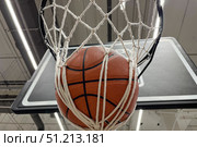 A basketball that hits the basket as it passes through the hoop and into the net. Basketball hoop in a professional basketball arena. Стоковое фото, фотограф Регина Ерофеева / Фотобанк Лори