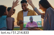 A family gathers outdoors at sunset, engaging in a joyful virtual connection while sharing smiles and laughter around a tablet. Стоковое AI-видео, аниматор Данила Большаков / Фотобанк Лори