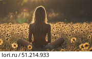 A person enjoys a serene meditation experience surrounded by vibrant sunflowers as the sun sets, creating a tranquil atmosphere in nature. Стоковое AI-видео, аниматор Данила Большаков / Фотобанк Лори