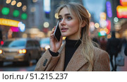 A young woman appears engaged in a phone conversation on a bustling New York street, illuminated by colorful lights and urban energy. Стоковое AI-видео, аниматор Данила Большаков / Фотобанк Лори
