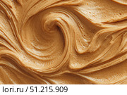 Creamy peanut butter spread swirl surface. Closeup, full frame. Crunchy Peanut butter background. American cuisine traditional product. Appetizing textured smears. Food paste from ground roasted nuts. Стоковое AI-изображение, AI-художник Марина Демидюк / Фотобанк Лори