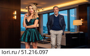 Wealthy mature man with beautiful young blonde woman in luxury apartment, rich couple posing in modern home, concept of success and lifestyle. Стоковое AI-изображение, AI-художник Павел Муравьев / Фотобанк Лори
