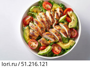 Grilled chicken salad with avocado and tomatoes in a white bowl on a light background, top view, flat lay. Healthy food idea. Concept for healthy eating, weight loss, or body-building advertising. Стоковое AI-изображение, AI-художник Марина Демидюк / Фотобанк Лори