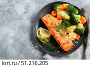 Steamed fish with with broccoli, carrot hot black pan. Baked salmon gray background. Paleo, keto, lshf, or dash diet. Fish and vegetables. Oven dish, gluten free, clean eating, balanced healthy food. Стоковое AI-изображение, AI-художник Марина Демидюк / Фотобанк Лори