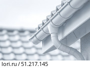 Contemporary Gutter Installed on a Residential House Roof to Enhance Functionality. Clean well maintained rain gutter system. Roof architecture effectively. Polymer storm drainage. Home architectural. Стоковое AI-изображение, AI-художник Марина Демидюк / Фотобанк Лори