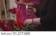 a woman glues a lump with hot liquid glue in the process of creating a Christmas ornate decoration for her home. Стоковое видео, видеограф Strunov David / Фотобанк Лори