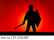 Silhouette of a soldier armed with sword and shield, with sun setting in background. Oleg Zabielin / Stocktrek Images/TASS. Стоковое фото, агентство ТАСС / Фотобанк Лори