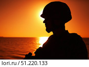 Silhouette of a soldier patrolling the coastline at sunset. Oleg Zabielin / Stocktrek Images/TASS. Стоковое фото, агентство ТАСС / Фотобанк Лори
