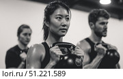 Diverse athletes performing kettlebell exercises, displaying muscular strength and fitness commitment during high intensity cross training session. Стоковое AI-изображение, AI-художник Юрий Поздников / Фотобанк Лори