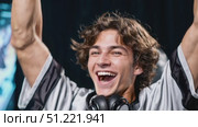 Young male gamer celebrating victory, wearing gaming headset and raising arms triumphantly after winning competitive esports match, displaying pure gaming excitement. Стоковое AI-видео, аниматор Юрий Поздников / Фотобанк Лори