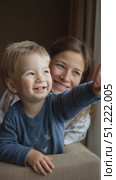 Infant boy eagerly pointing finger, mother gazing with tender smile, capturing intimate parent child connection and pure emotional warmth. Стоковое AI-видео, аниматор Юрий Поздников / Фотобанк Лори