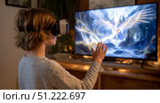 Child using virtual reality headset for metaverse, child looking into VR glasses. Little girl boy with futuristic glasses having fun, teenager playing video games. Technology, simulator, oculus future. Стоковое AI-изображение, AI-художник ALLA YURTAYEVA / Фотобанк Лори