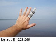 Man showing broken finger with splint near lake during summer vacation. Стоковое фото, фотограф Дмитрий Цветков / Фотобанк Лори