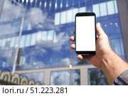 Businessman holding smartphone with blank screen in front of office building. Стоковое фото, фотограф Дмитрий Цветков / Фотобанк Лори