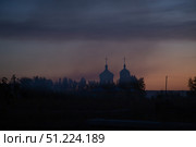 Bright blue-red sunset sky on summer evening, and dark silhouette of two domes of Orthodox church. Стоковое фото, фотограф irisff / Фотобанк Лори