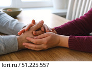Couple holding hands at home. Happy Man and Woman. Two Loving Hands Together on the Couch Sharing Deep Affection and Love in Details. Intimate connection. Close-up of Intertwined female and male hands. Стоковое фото, фотограф Марина Демидюк / Фотобанк Лори