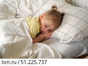Peaceful adorable baby sleeping on a bed at home. Slumbering little child. Two years old girl sleeps peaceful at domestic room interior background. Serene dream. Cute face close up. Deep kid slumber. Стоковое фото, фотограф Марина Демидюк / Фотобанк Лори