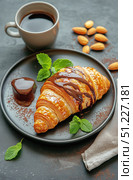 Croissant With Chocolate Drizzle and Drink Served on Plate With Almonds and Mint. Стоковое AI-изображение, AI-художник Юлия Гапеенко / Фотобанк Лори