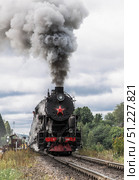 An old Soviet steam locomotive of the L series. The Ruskeala Express retro train is on its way to the mountain park. Thick smoke is coming from the chimney. Russia, Republic of Karelia, Sortavala, August 11, 2025. Редакционное фото, фотограф Photojuli / Фотобанк Лори