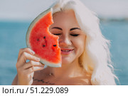 Watermelon Woman Beach Summer: Blond woman enjoys watermelon slice near ocean, sunny day. Стоковое фото, фотограф svetograph / Фотобанк Лори