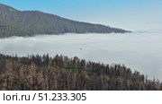 A Breathtaking Aerial View of FogCovered Mountains Following Recent Wildfires and Destruction. Стоковое видео, видеограф Vladimir Vintonjak / Фотобанк Лори