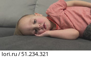 A Child is Relaxing on a Cozy Couch This Captures a Beautiful Moment of Peaceful Serenity. Стоковое видео, видеограф Olesia Kondrateva / Фотобанк Лори