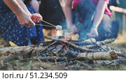Graduating students sharing marshmallows near crackling campfire, marking summer's start with joyful camaraderie. Стоковое видео, видеограф Mikhail Davidovich / Фотобанк Лори