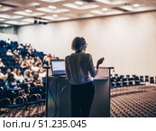 Female speaker giving a talk on corporate business conference. Unrecognizable people in audience at conference hall. Business and Entrepreneurship event. Стоковое фото, фотограф Matej Kastelic / Фотобанк Лори