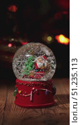 Hand Gently Shakes a Snow Globe With Santa Claus and Christmas Decorations. Стоковое видео, видеограф Ольга Коваленко / Фотобанк Лори