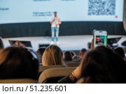 Audience attending presentation with speaker on stage and smartphone recording. Стоковое фото, фотограф Антон Гвоздиков / Фотобанк Лори