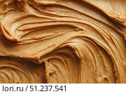 Creamy peanut butter spread swirl surface. Closeup, full frame. Crunchy Peanut butter background. American cuisine traditional product. Appetizing textured smears. Food paste from ground roasted nuts. Стоковое AI-изображение, AI-художник Марина Демидюк / Фотобанк Лори