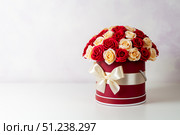 A bouquet of pink and white roses decorated in a hat box on a light background. Стоковое фото, фотограф Енваев Андрей / Фотобанк Лори