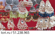 Colorful jhumka earrings with pearls and gemstones are hanging and showing indian craftsmanship. Стоковое видео, видеограф Mikhail Davidovich / Фотобанк Лори