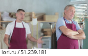 Young man scolding elderly man in sewing workshop. Стоковое видео, видеограф Яков Филимонов / Фотобанк Лори