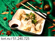 Dumplings on Plate Surrounded by Spices Evoke Tradition and Warmth. Стоковое фото, фотограф Aleksandr Golubev / Фотобанк Лори