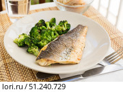 fried fillet of sea bass with garnish of broccoli on black warm stone plate. Стоковое фото, фотограф Татьяна Яцевич / Фотобанк Лори