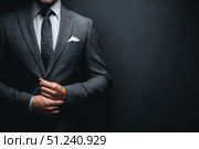 Caucasian businessman in a formal wear isolated on a dark gray background. Confident man in suit standing over black wall. Business concept. Mature executive manager, proud lawyer, successful leader. Стоковое AI-изображение, AI-художник Марина Демидюк / Фотобанк Лори