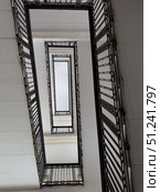 Modern staircase with metal railings viewed from below in geometric perspective. Стоковое фото, фотограф Антон Гвоздиков / Фотобанк Лори