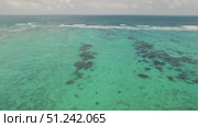 Clear turquoise sea water with patches of reef viewed from above on sunny day. Стоковое видео, видеограф Igor Tichonow / Фотобанк Лори