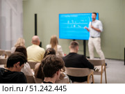 Speaker giving presentation to engaged audience in modern conference room. Стоковое фото, фотограф Антон Гвоздиков / Фотобанк Лори