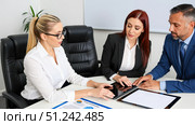 Business team working together in boardroom, group of colleagues at meeting table with tablets and documents, professionals having corporate discussion. Стоковое AI-изображение, AI-художник Павел Муравьев / Фотобанк Лори