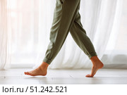 Close up focus on young female feet walking barefoot on clean tile floor at home. Young woman standing on warm floor indoors, underfloor heating concept. Woman's legs in bathroom. Floor heating. Стоковое AI-изображение, AI-художник Марина Демидюк / Фотобанк Лори