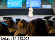 Speaker presenting at conference viewed from audience perspective in modern auditorium. Стоковое фото, фотограф Антон Гвоздиков / Фотобанк Лори
