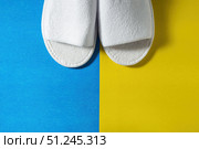 Top view of white slippers on a blue and yellow background. Copy space for text. Стоковое фото, фотограф Зарифа Арсланова / Фотобанк Лори