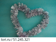 Shape of the heart of silver tinsel on a blue background, top view. Стоковое фото, фотограф Зарифа Арсланова / Фотобанк Лори